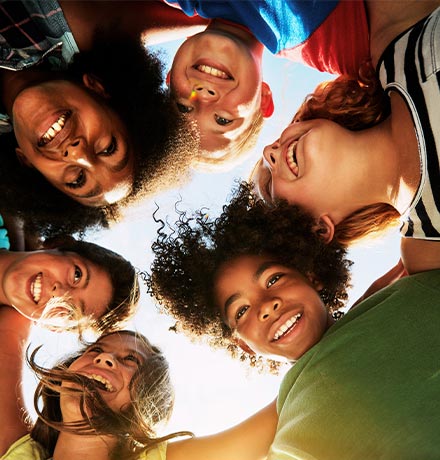 Children in a circle hugging.