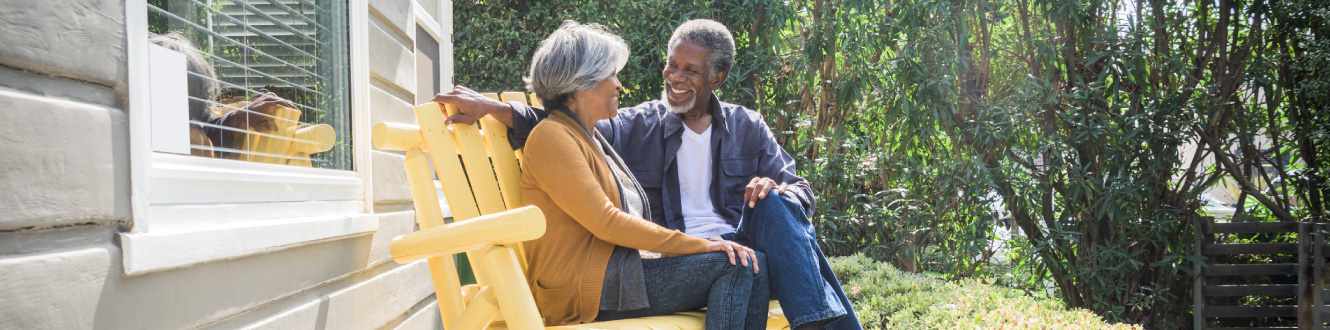 A couple sitting outside on their porch.