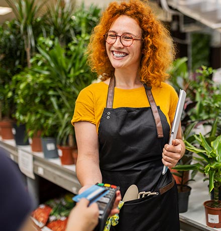 Person paying with a card at a plant store.