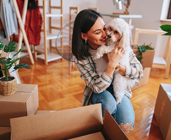 Woman and dog unpacking boxes