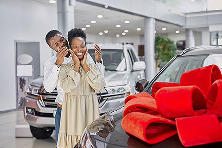 Man surprising woman with car.