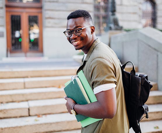 Male student with books and a backpack.