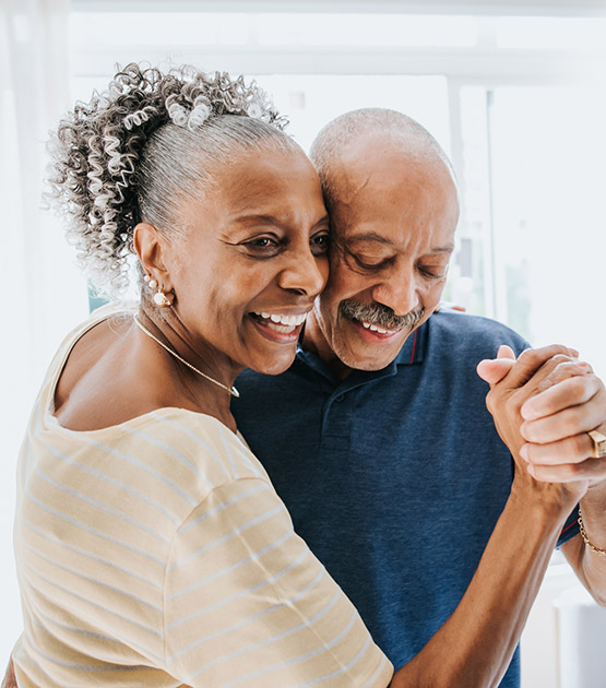 Mature couple dancing at home