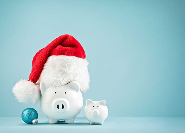 A piggy bank wearing a Christmas hat. 